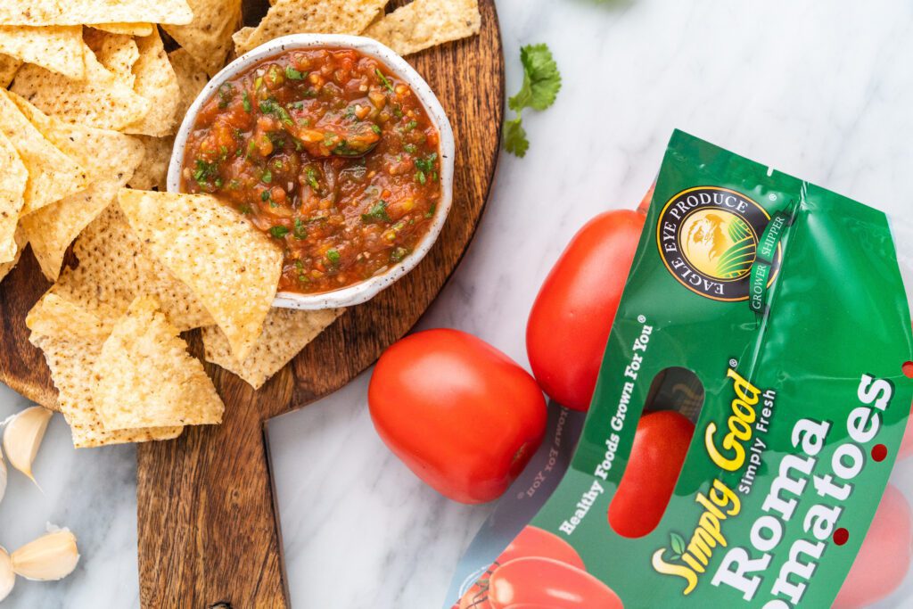 A Bowl of Chips With a Salsa Dip on a Wooden Platter