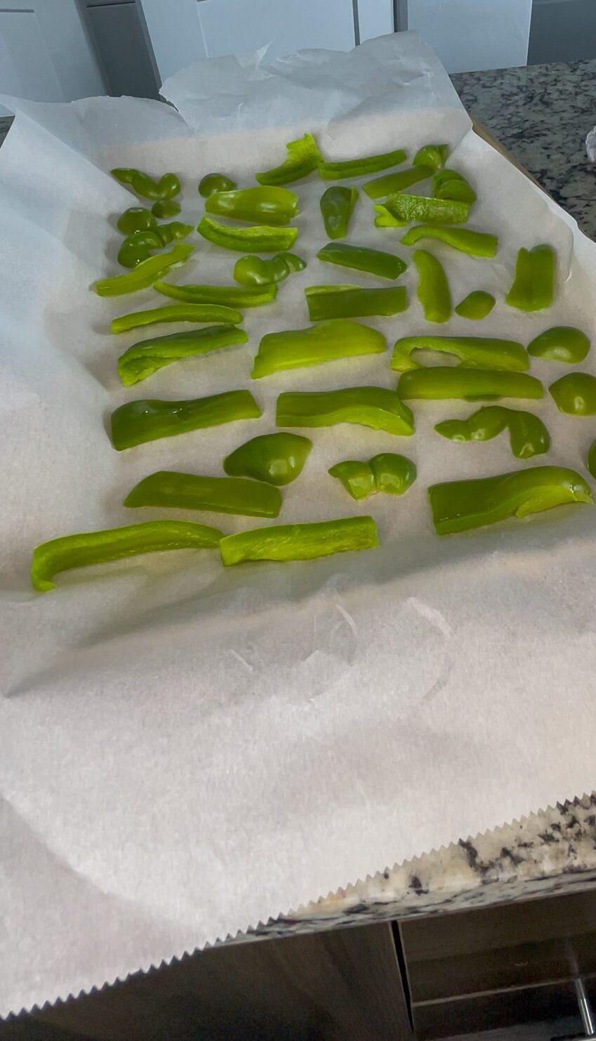 Peppers on some parchment paper and a pan