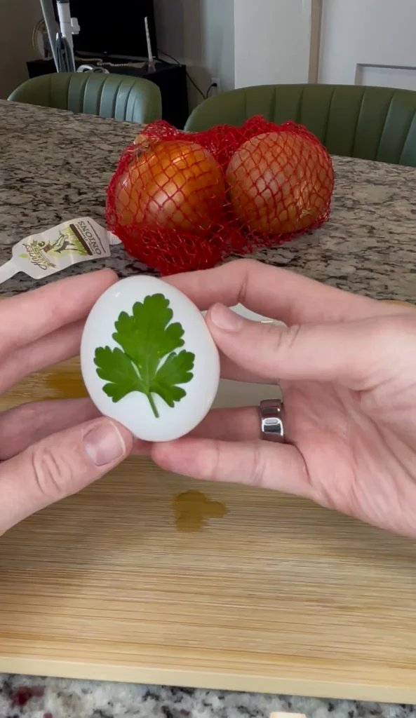 Herb pressed against egg preparing to be placed in nylon.