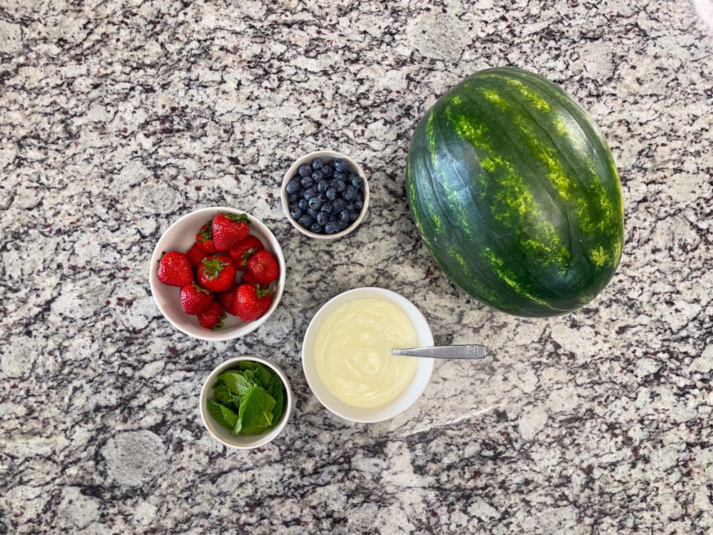 Strawberries, mint, blueberries, yogurt, and watermelon ingredients for recipe