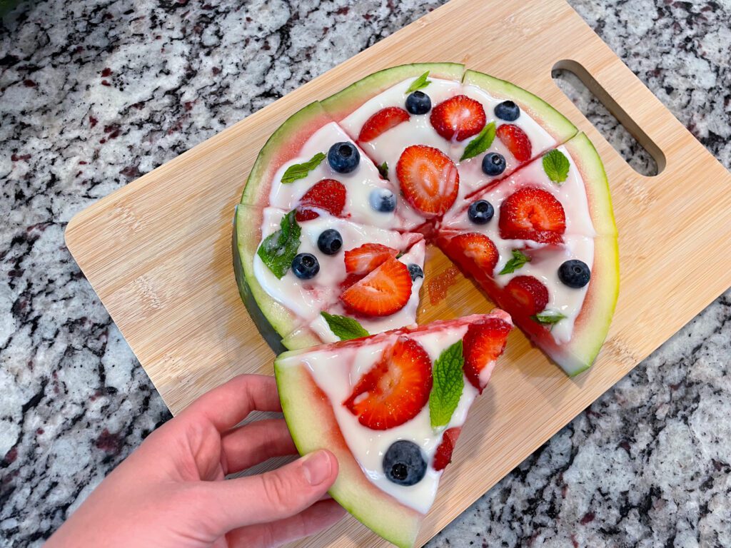 Watermelon dessert pizza on cutting board