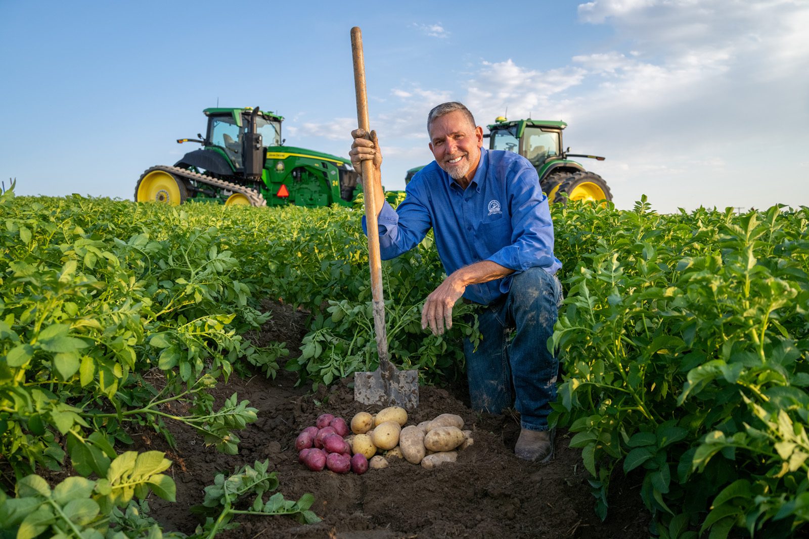 Newman Giles, Founder of Eagle Eye Produce, kneeling in a potato field