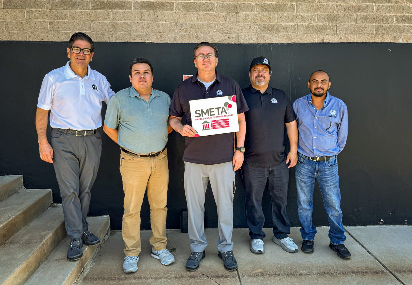 Eagle Eye Produce team holding a SMETA 4 Pillar Certified Factory sign