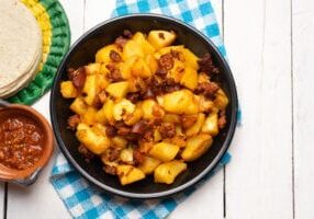 Traditional mexican potatoes with chorizo on white background