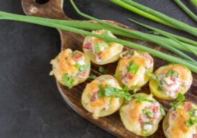 Hot baked stuffed potatoes with cheese, bacon, parsley on a wooden Board.
