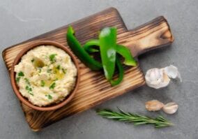 Flat lay view at vegetable Hummus dip dish topped with olive oil served with green sweet bell pepper slices