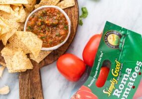 A Bowl of Chips With a Salsa Dip on a Wooden Platter